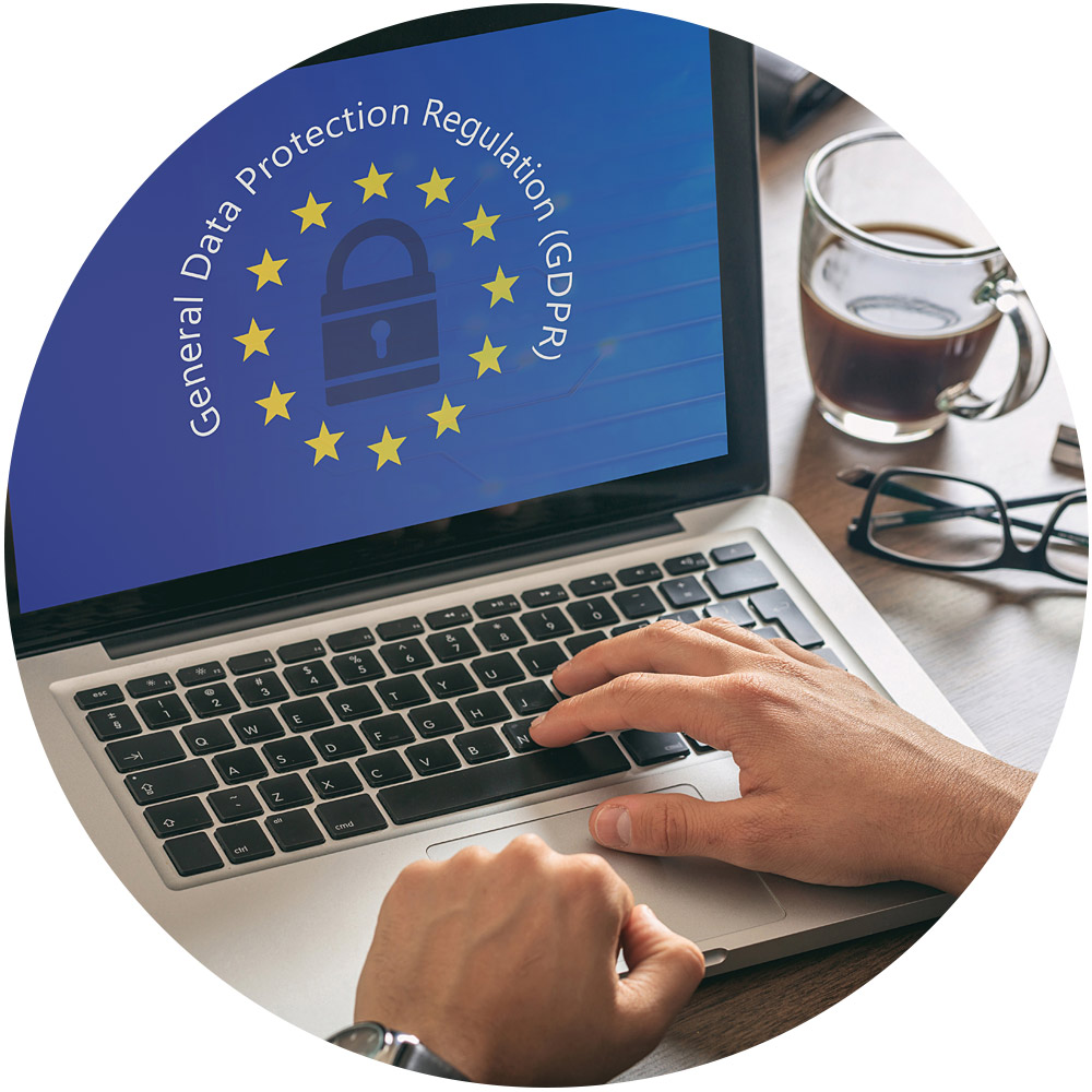 Hände tippen auf einem Laptop, auf dem ein DSGVO-Logo mit einem Vorhängeschloss und Sternen zu sehen ist, das den Datenschutz in der Europäischen Union symbolisiert, in Deutschland als DSGVO bekannt. Neben dem Laptop steht eine Glastasse mit Kaffee, was die perfekte Kulisse für effizientes Management bietet.